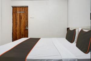 PhūrsungiにあるCollection O Aachal Hotel & Lodgingの木製のドアが備わるドミトリールームのベッド1台分です。