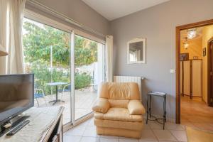 a living room with a chair and a television at Au Paradis Des Hotes - Chambre Ile in Fouras