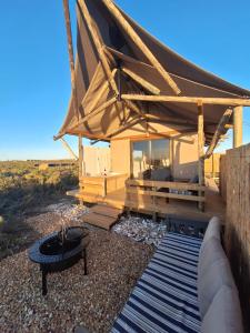 a tent with a fire pit in the middle of a yard at Trekosglamping luxury tents 