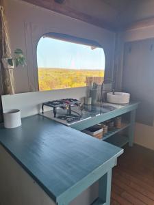 a kitchen with a counter with a stove and a window at Trekosglamping luxury tents 