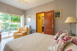 a bedroom with a bed and a chair and a window at Au Paradis Des Hotes - Chambre Ile in Fouras