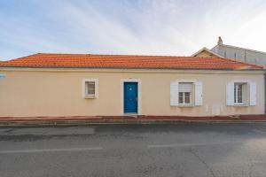 a house with a blue door on a street at Au Paradis Des Hotes - Chambre Ile in Fouras