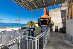 a balcony with a pizza oven with a view of the ocean at Apartments with parking space Sumpetar, Omis - 950 in Sumpetar