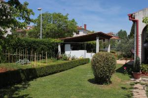 einen Garten mit einem Zaun und einem Haus in der Unterkunft Apartments with parking space Rovinj - 7656 in Rovinj