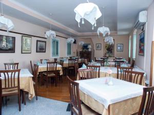 a restaurant with tables and chairs with white tablecloths at Rooms by the sea Rabac - Labin - 3016 in Rabac