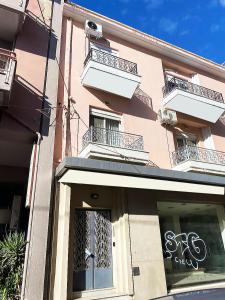 a pink building with a sign in a window at ZT Luxury Apartment in Xanthi +21 photos