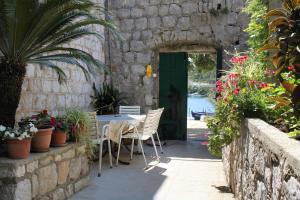 a patio with a table and chairs and a green door at Double Room Zaton Mali 8997c in Zaton
