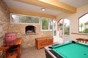a room with a pool table and a stone fireplace at Seaside apartments with a swimming pool Prigradica, Korcula - 9290 in Prigradica