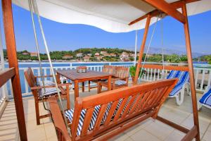 a porch with a table and chairs on a balcony at Seaside apartments with a swimming pool Lumbarda, Korcula - 9303 in Lumbarda