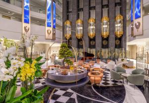 a lobby with chairs and tables and chandeliers at Delphin Palace Hotel in Lara +62 photos