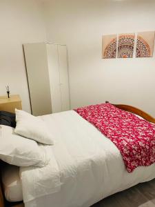 ein Schlafzimmer mit einem weißen Bett mit roten Blumen darauf in der Unterkunft Appartement fonctionnel in Malleval