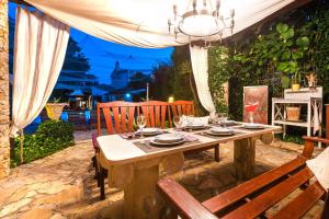 une table en bois avec des chaises et une table dans l'établissement Luxury villa with a swimming pool Rogoznica - 13374, à Rogoznica