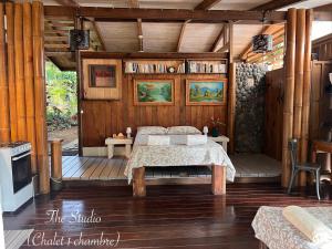 a bedroom with a bed on a wooden floor at My Mountain Home - Le Studio in Taravao
