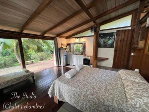 a bedroom with a bed and a wooden floor at My Mountain Home - Le Studio in Taravao +9 photos