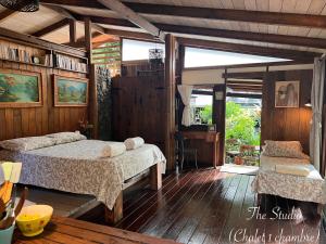 a bedroom with two beds in a room with wooden floors at My Mountain Home - Le Studio in Taravao