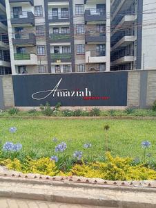 una señal frente a un edificio con flores en Cynergy 1b Apartment, Muthiga , Waiyaki Way, en Nairobi 2 fotos más