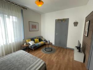 a room with a bed and a couch and a tv at Charmant appartement F1 in Fraize