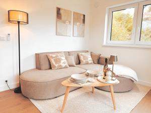a living room with a couch and a table at Tiny House mit Whirlpool und Sauna in Bermel