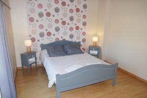 a bedroom with a bed and two night stands with two lamps at Gîte du Lieu Piquot in Gréville-Hague