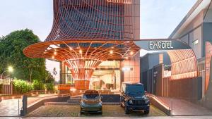 泗水EXCOTEL Design Hotel Surabaya的停在大楼前的两辆卡车