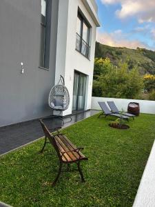 a yard with a bench and chairs on a house at The Barreto's Clive in Ponta do Sol