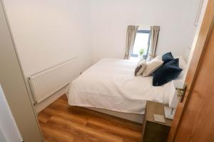 ein Schlafzimmer mit einem Bett mit Kissen und einem Fenster in der Unterkunft Rose Cottage in Killala