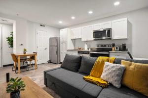 CozySuites Stunning 1BR in Downtown Pitts #03 في بيتسبرغ: غرفة معيشة مع أريكة ومطبخ