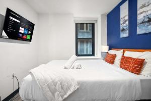 CozySuites Stunning 1BR in Downtown Pitts #03 في بيتسبرغ: غرفة نوم بسرير ابيض وعليه كلب