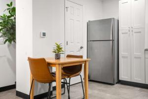 CozySuites Stunning 1BR in Downtown Pitts #03 في بيتسبرغ: طاولة وكراسي مع وجود ثلاجة في المطبخ +6 صور
