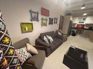 a living room with two couches and a kitchen at Quiet HOME in Hurghada +2 photos