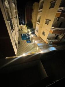 an overhead view of a building with a swimming pool at night at Quiet HOME in Hurghada