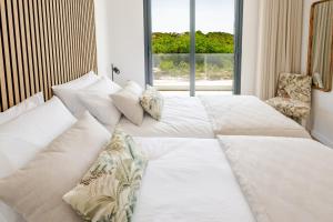 a bedroom with two white beds and a window at Vale Furado Sea & Nature - BY SCH - B in Vale Furado
