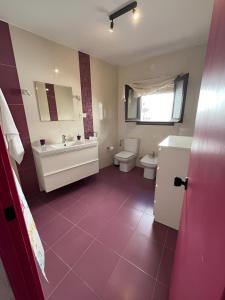 a bathroom with a toilet and a sink and a tub at La Casa Colores in Casares