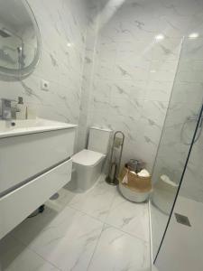 une salle de bains blanche avec toilettes et lavabo dans l'établissement Sweet Home Casa dos Arcos 310, à Praia da Rocha