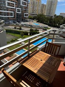 d'un balcon avec un banc en bois et 2 chaises. dans l'établissement Sweet Home Casa dos Arcos 310, à Praia da Rocha 6 autres photos