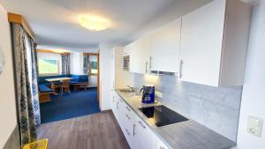 a kitchen with white cabinets and a dining room at Apart Marlen in Ischgl
