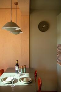 a dining table with a bottle of wine and a clock at Brzozowy Rożnów in Rożnów +18 photos