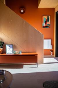 a living room with an orange wall and a bench at Brzozowy Rożnów in Rożnów