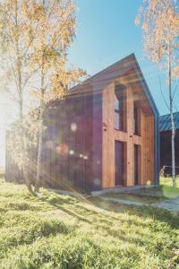 a wooden house with a large door in a field at Brzozowy Rożnów in Rożnów