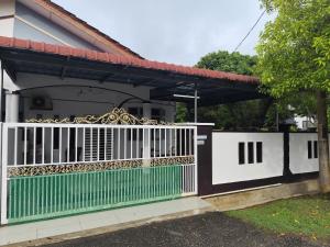 a gate to a house with a white fence at AHA Homestay Temerloh with 3 bedrooms, 2 toilet in Temerloh +5 photos