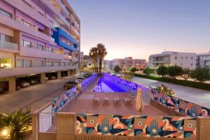 an apartment building with a pool in a parking lot at UC Hall Residence in Aglantzia