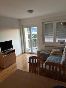 a living room with a couch and a tv at Apartma Roberto - Ankaran in Ankaran