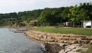 a retaining wall next to a body of water at Apartma Roberto - Ankaran in Ankaran