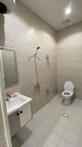 a bathroom with a shower and a toilet and a sink at شقق المصيف الفندقيه in Hafr Al Baten