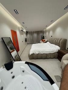 a bathroom with a bath tub and a bed at سويت بني معن in Al Hofuf