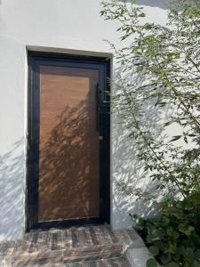 a door with a shadow of a tree on a building at سويت بني معن in Al Hofuf
