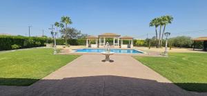 a swimming pool with a fountain in a park at Casa Rural Los Gaspares in La Carlota