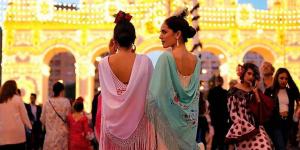 two women in dresses walking in a crowd of people at Casa Rural Los Gaspares in La Carlota +80 photos