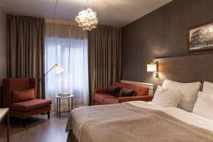 a hotel room with a bed and a chair at Home Hotel Grand Bodø in Bodø +145 photos