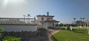 a white house with a porch and a fence at Casa Rural Los Gaspares in La Carlota